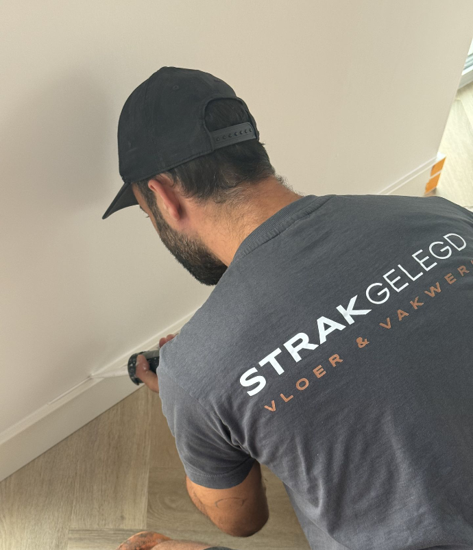Collega die de plinten netjes afkit